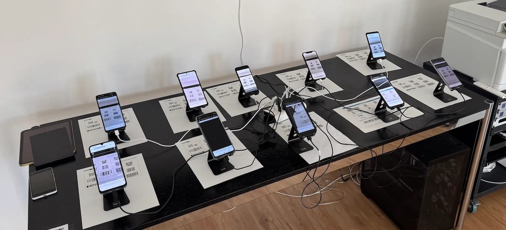 Photo of the STRICH QA test bench, with ten smartphones running a stress test on the barcode scanning SDK